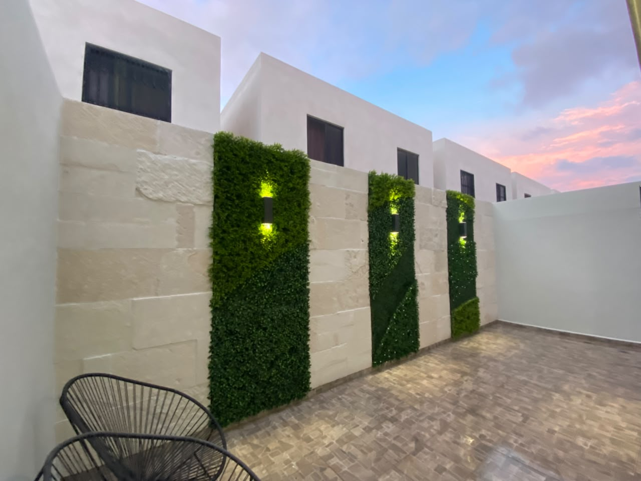 Muros verdes e iluminación exterior, con piedra galarza