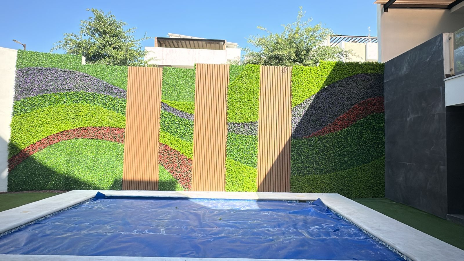 Jardín vertical y lambrín junto a alberca