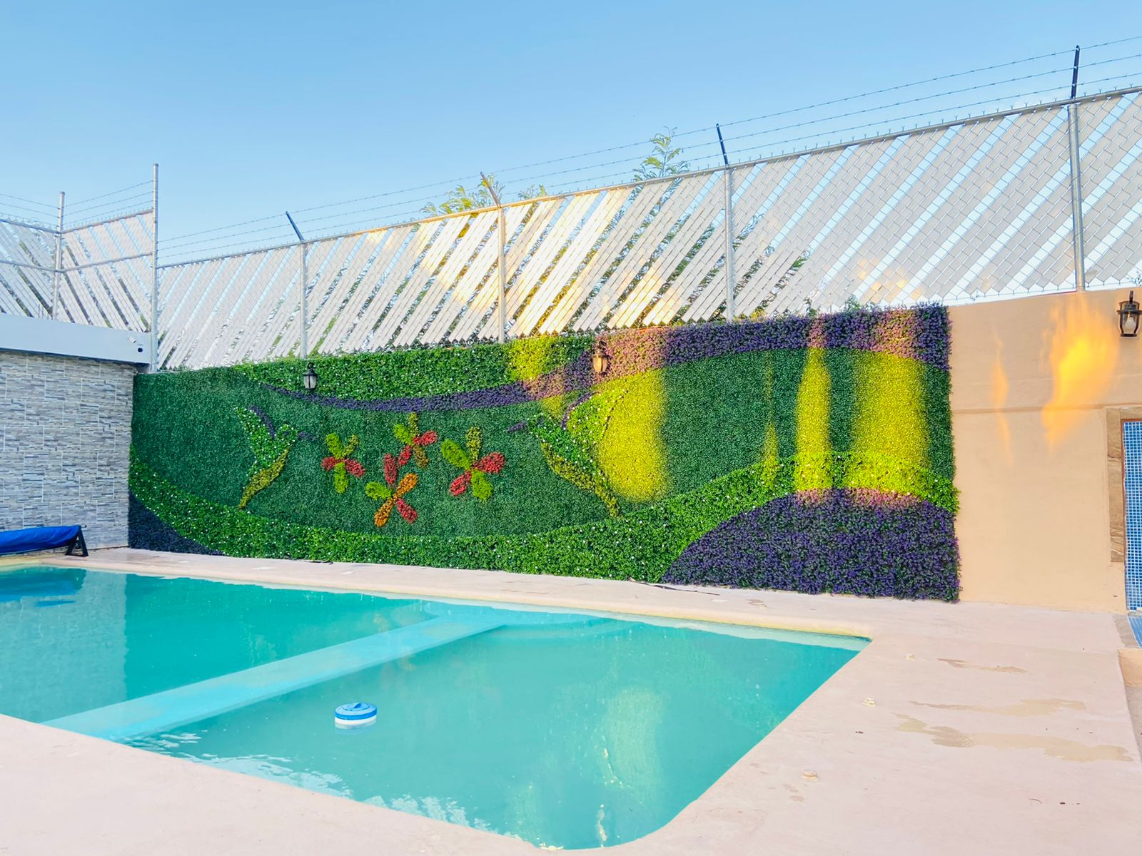 Muro verde decorativo en área de alberca